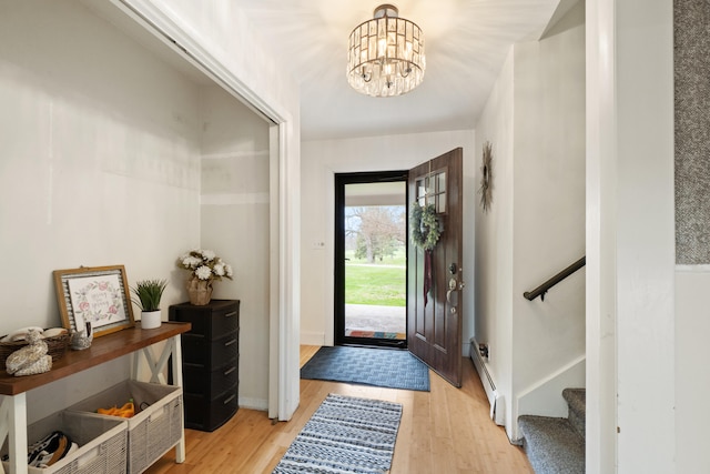 entryway featuring baseboards, an inviting chandelier, stairway, and light wood-style floors
