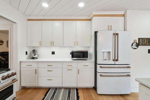kitchen featuring decorative backsplash, light wood-style floors, light countertops, recessed lighting, and white appliances