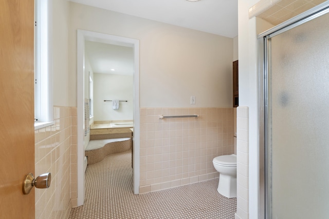 full bathroom with tile walls, a wainscoted wall, toilet, and tile patterned flooring