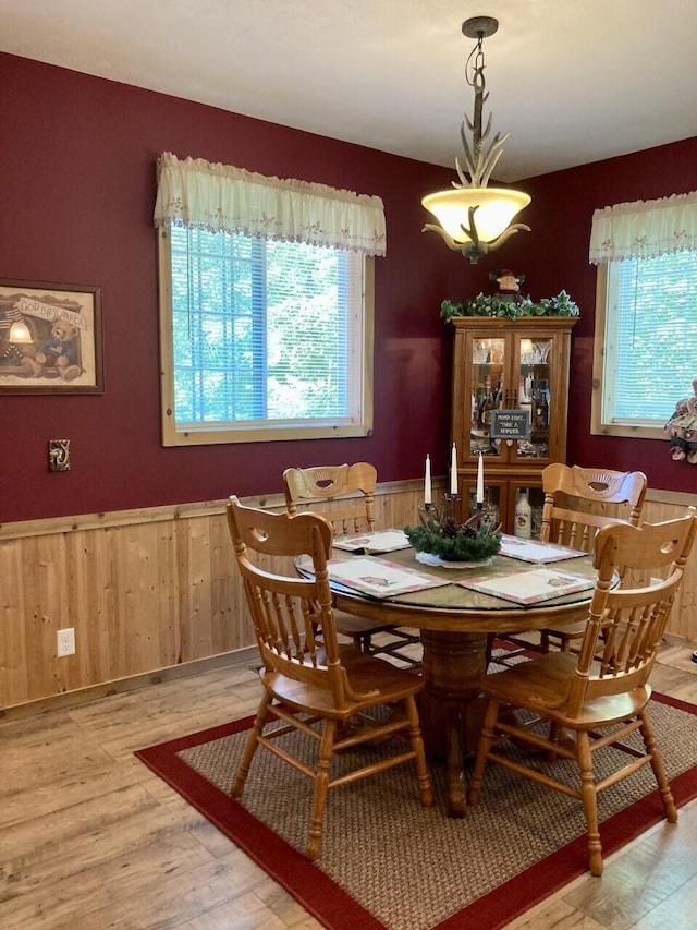 dining space with light wood-type flooring, wainscoting, and plenty of natural light