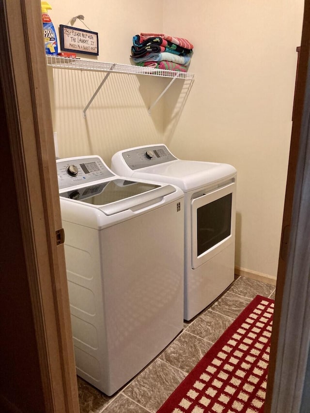 clothes washing area featuring washer and dryer, laundry area, and baseboards