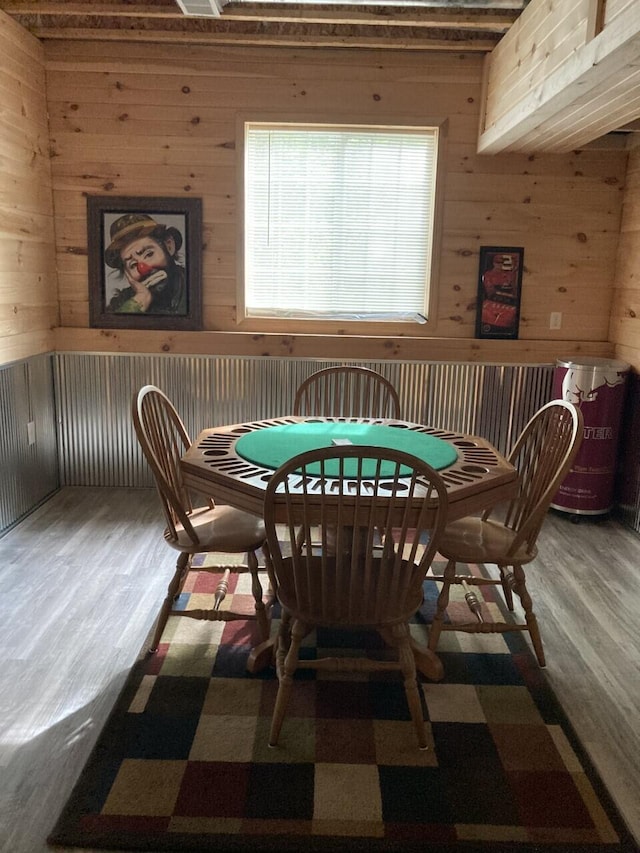 dining area with wood walls and wood finished floors