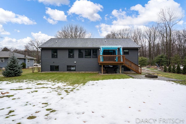 back of property featuring stairs, a yard, a deck, and a fire pit