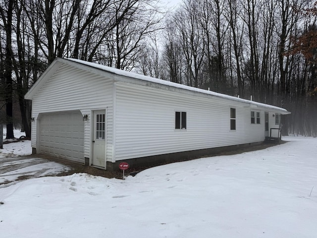 snow covered property with a garage