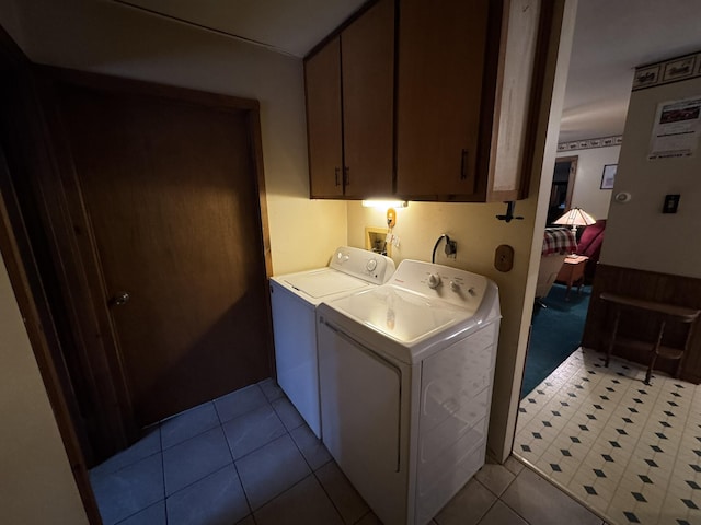 washroom with cabinet space, independent washer and dryer, and tile patterned floors