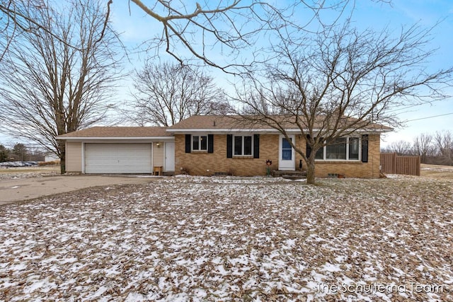 single story home with brick siding, an attached garage, crawl space, fence, and driveway