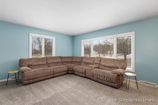 living area featuring carpet flooring, visible vents, and baseboards