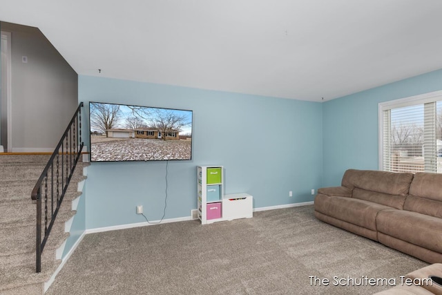 carpeted living area with stairway and baseboards