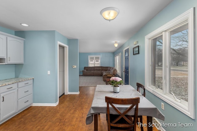 dining space with dark wood-style floors and baseboards