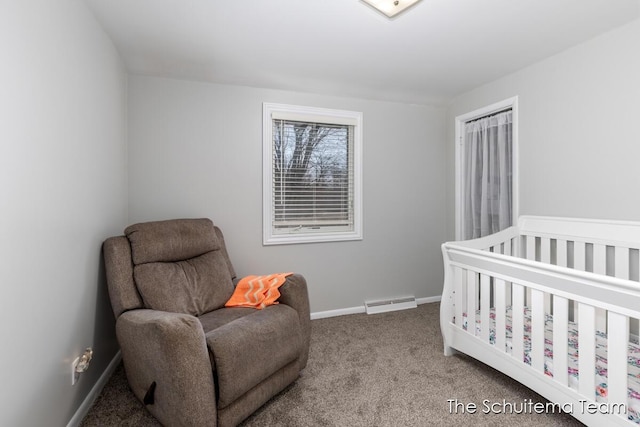 bedroom featuring a nursery area, carpet floors, visible vents, and baseboards