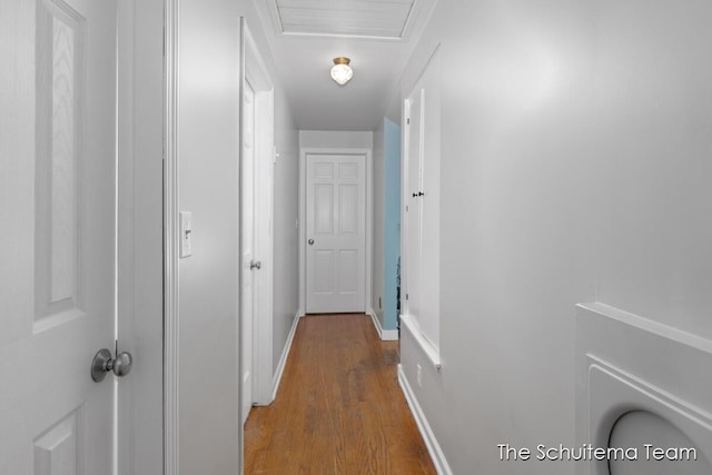 hall with wood finished floors, attic access, and baseboards