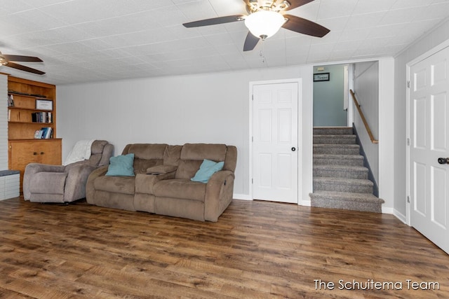 living room with ceiling fan, stairs, and wood finished floors