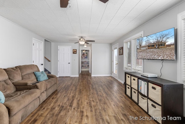 living room with stairs, ceiling fan, baseboards, and wood finished floors