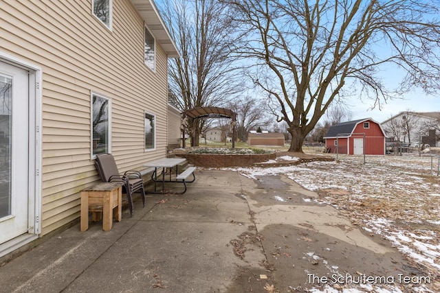 view of patio with a barn and an outbuilding