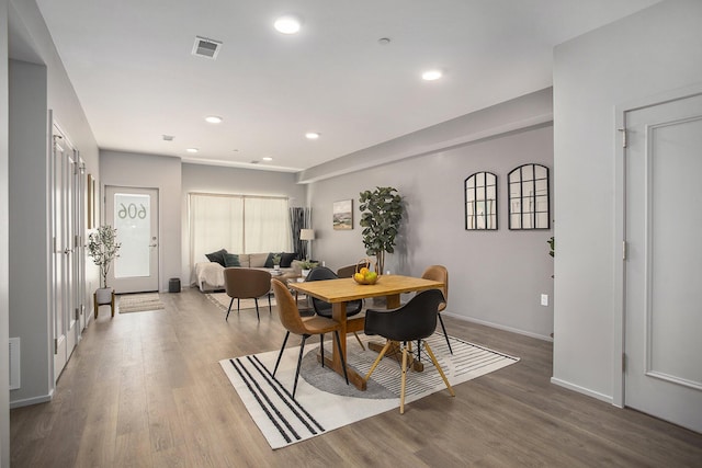 dining space featuring baseboards, wood finished floors, visible vents, and recessed lighting