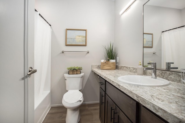full bathroom featuring toilet, baseboards, wood finished floors, and vanity