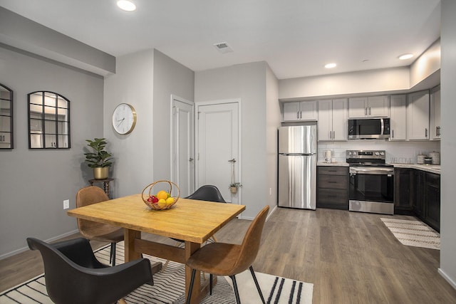 dining area with dark wood-style floors, recessed lighting, visible vents, and baseboards