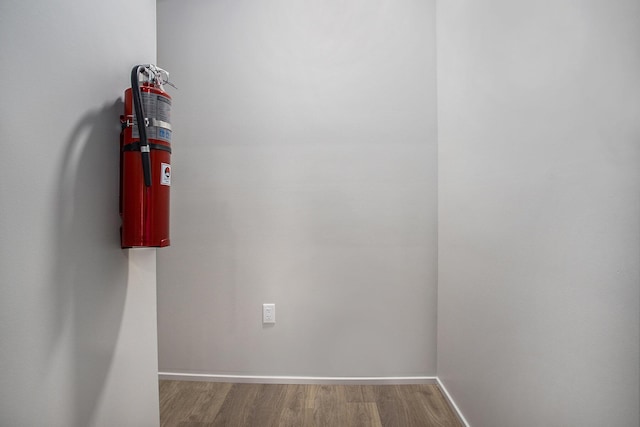 interior space with a fire extinguisher, baseboards, and wood finished floors