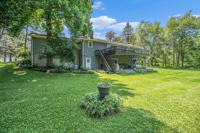 rear view of property featuring a patio, a chimney, a lawn, stairway, and a wooden deck