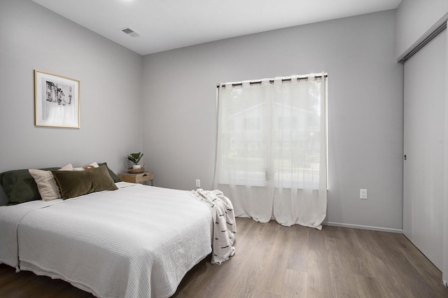 bedroom with visible vents and wood finished floors