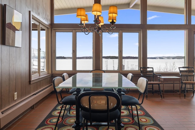 tiled dining area with lofted ceiling with beams, a notable chandelier, wood walls, a water view, and baseboard heating