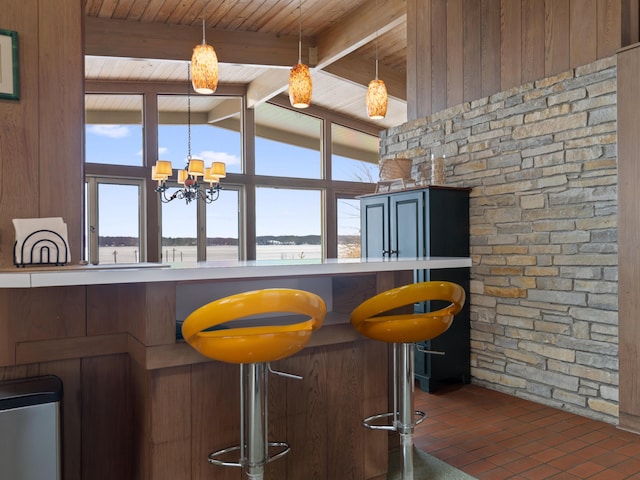 bar featuring a chandelier, wooden ceiling, vaulted ceiling with beams, and hanging light fixtures