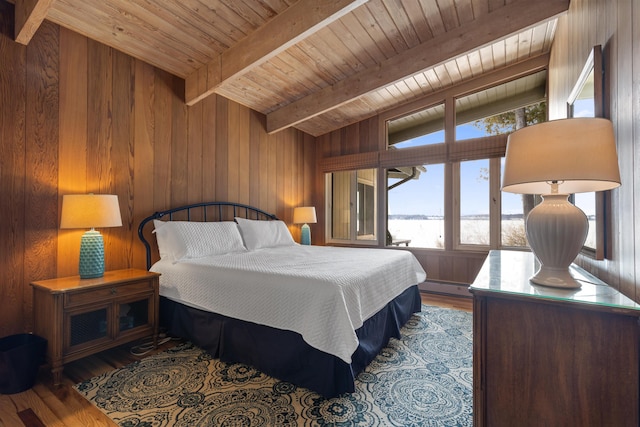 bedroom with wooden ceiling, wood finished floors, wood walls, a baseboard heating unit, and beam ceiling