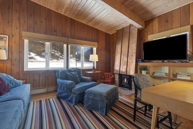 living room with beam ceiling, a baseboard heating unit, wood ceiling, wood walls, and wood finished floors