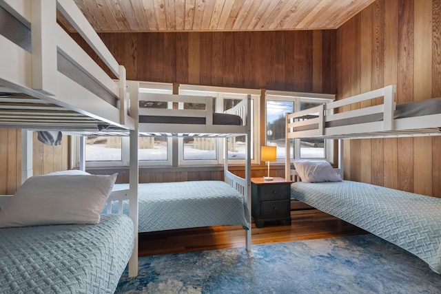 bedroom with wooden ceiling, wood walls, and wood finished floors