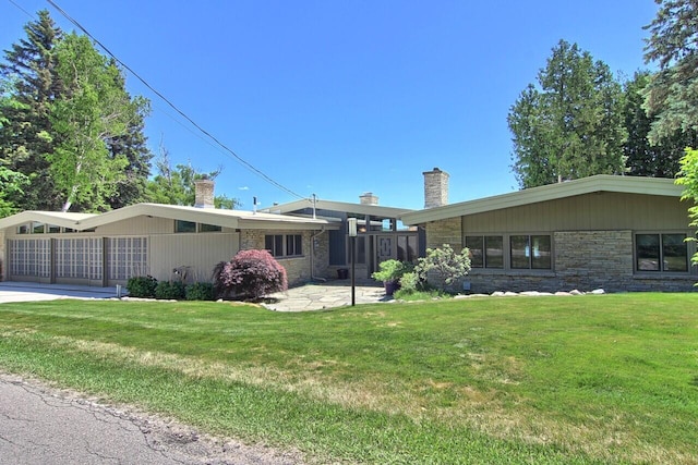 mid-century modern home featuring stone siding, a patio, a chimney, and a front lawn