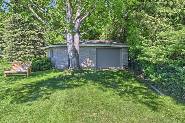 view of yard featuring a garage and an outbuilding