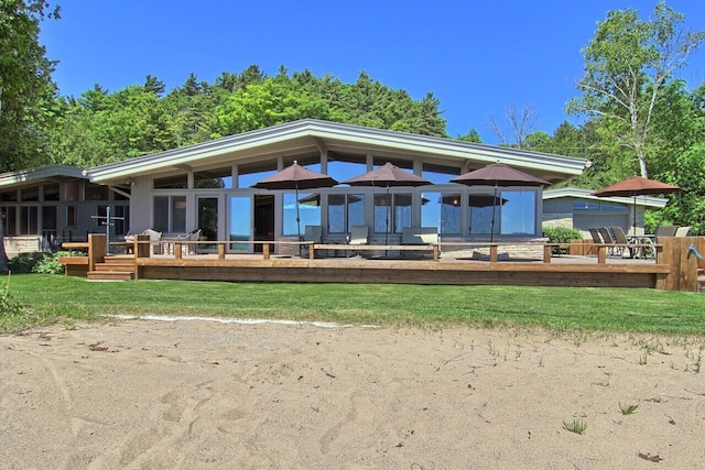 back of house featuring a deck and a yard