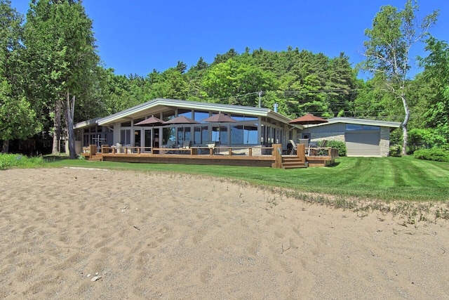 rear view of property with a wooden deck, an outdoor structure, and a yard