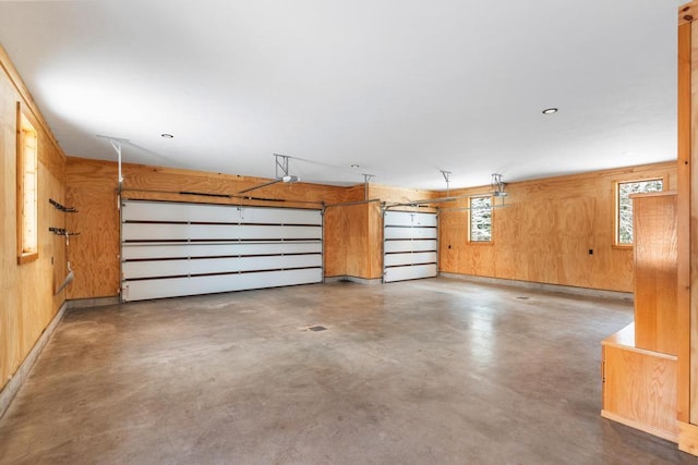 garage with a garage door opener and wood walls