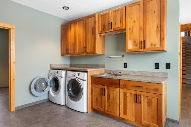 laundry area with separate washer and dryer, a sink, cabinet space, and baseboards