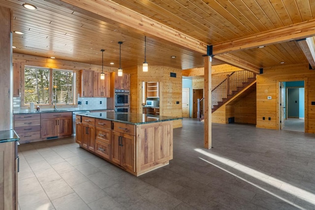 kitchen with stainless steel double oven, wooden ceiling, wood walls, open floor plan, and beamed ceiling