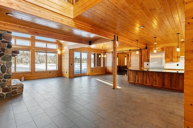 kitchen with a barn door, dark countertops, wood ceiling, open floor plan, and built in refrigerator