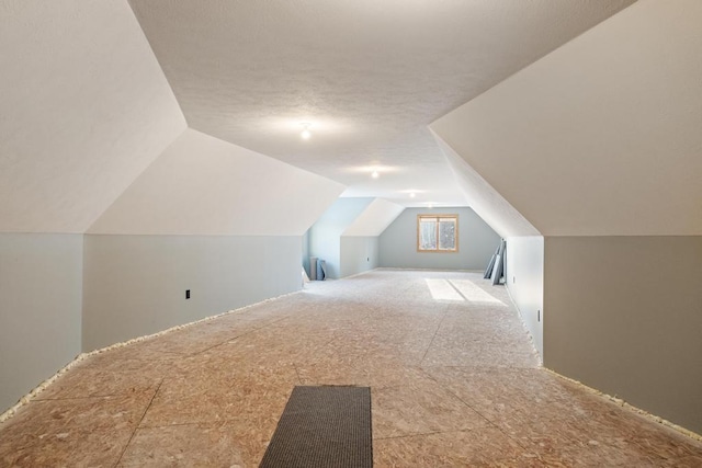 additional living space with vaulted ceiling and a textured ceiling