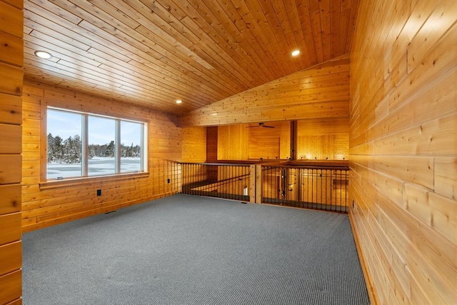 interior space featuring lofted ceiling, wooden ceiling, carpet flooring, and wooden walls