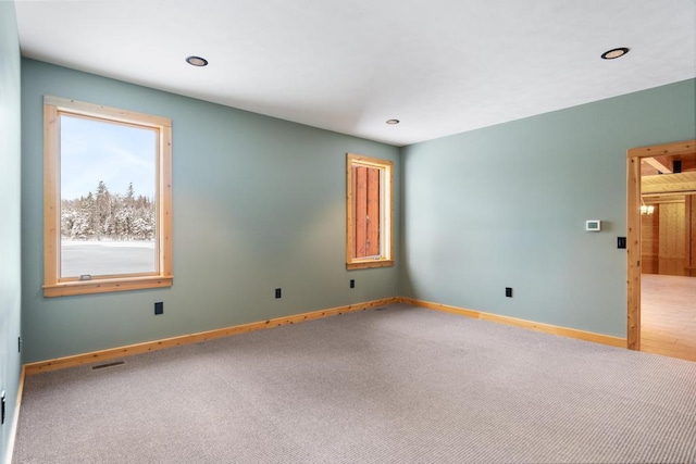 unfurnished room with recessed lighting, carpet flooring, visible vents, and baseboards