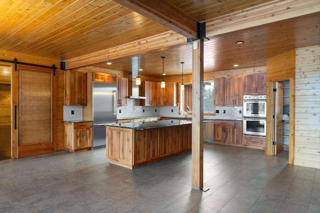 kitchen featuring tasteful backsplash, a barn door, wooden ceiling, appliances with stainless steel finishes, and brown cabinets