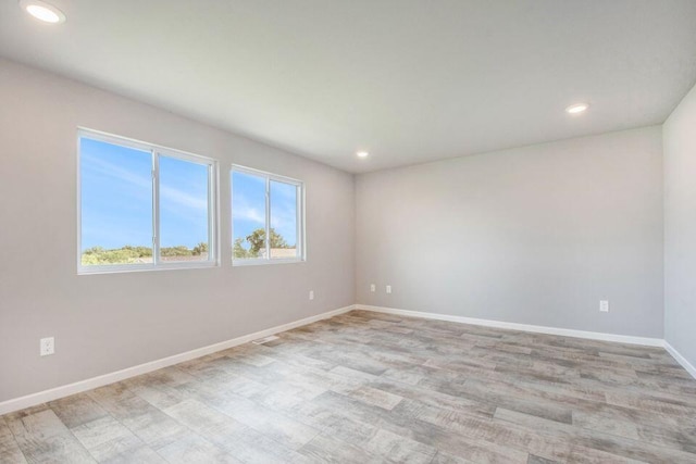 unfurnished room with light wood-style floors, recessed lighting, and baseboards