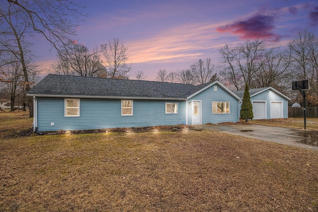 single story home with an outbuilding, a yard, roof with shingles, and a garage