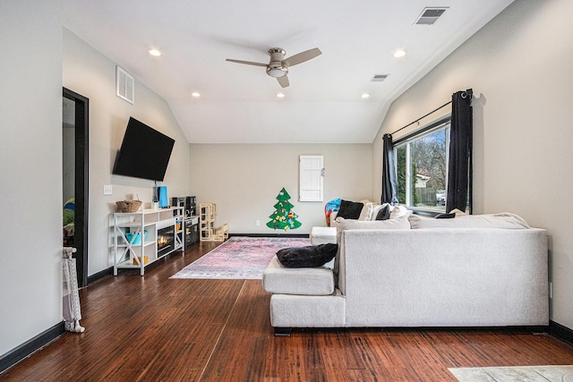 living room with vaulted ceiling, wood finished floors, and visible vents