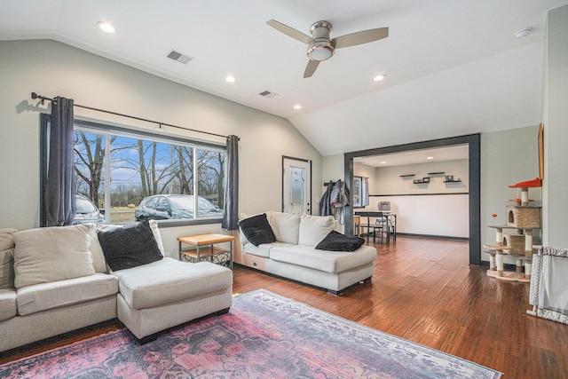 living area featuring lofted ceiling, visible vents, and wood finished floors