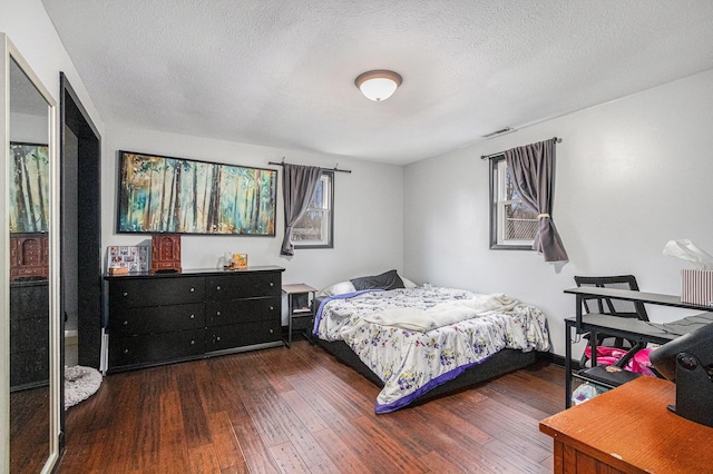 bedroom with a textured ceiling, wood-type flooring, and visible vents