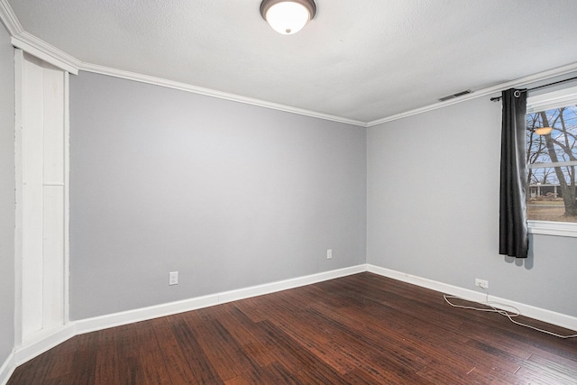 unfurnished room with ornamental molding, dark wood finished floors, visible vents, and baseboards