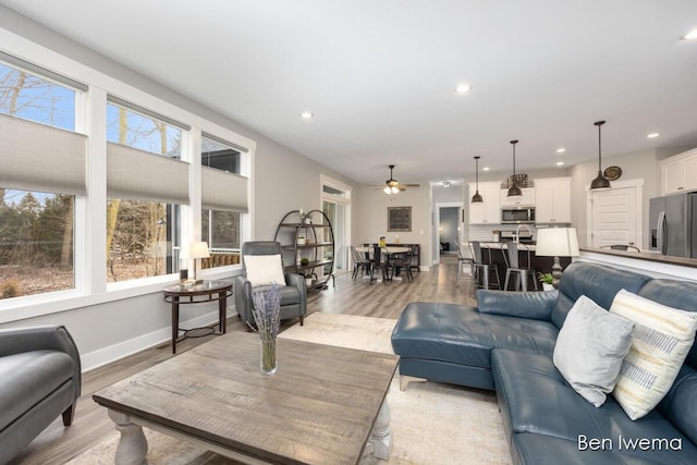 living room with baseboards, plenty of natural light, light wood-style flooring, and recessed lighting