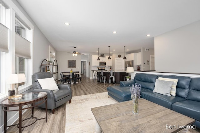 living area with light wood-type flooring, a wealth of natural light, and recessed lighting