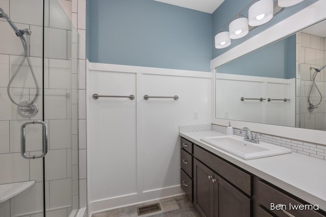 full bathroom featuring a stall shower, visible vents, and vanity